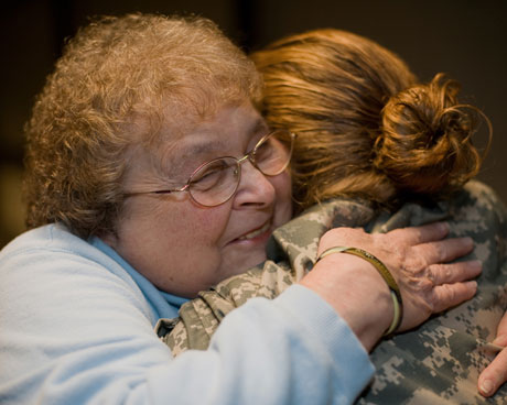 The Way We Get By Joan Gaudet gives a hug to a returning troop.