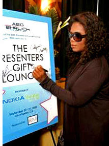 Oprah signs the poster for charity.