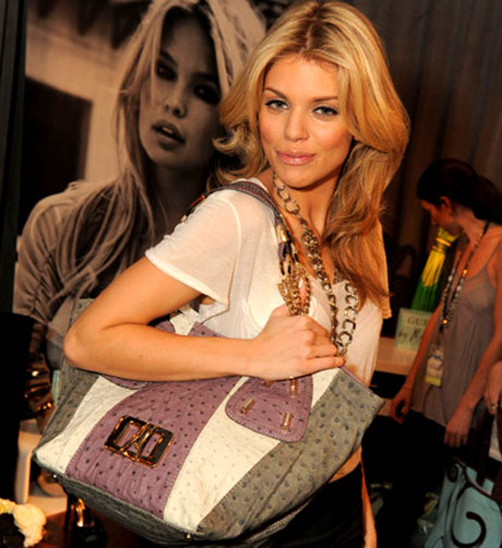 AL McCord proudly sports her GUESS by Marciano handbag.