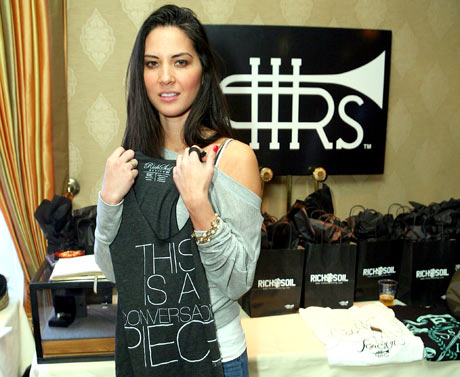 Olivia Munn with her Rich Soil tank reading "This is a conversation piece."