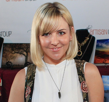 Actress Helene Yorke posing with the Vitrine Designs bullet necklace at GBK Golden Globes gift lounge.