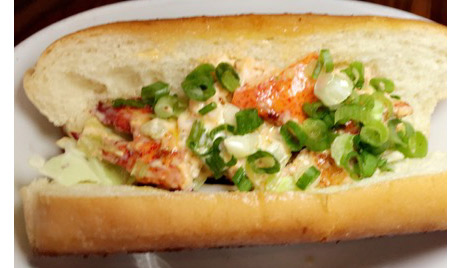 FishBar's Lobster Roll has warm lobster salad with shredded cabbage on a toasted soft roll. It is melt-in-your-mouth delicious!