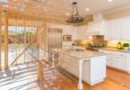 Two images blended together—the left side features the framing of a home, while the right is a completed kitchen renovation.