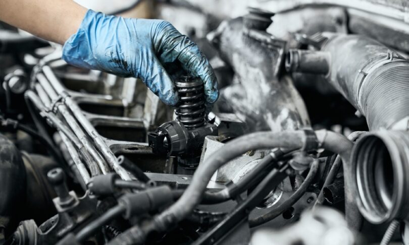 There's a pile of standard silver truck parts sitting against a plain background. There's hubcaps, filters, and more.