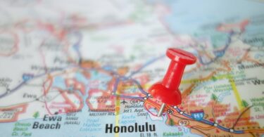 A colorful map zoomed in on Honolulu on the island of Oʻahu, with a red tack marking a location near the airport.