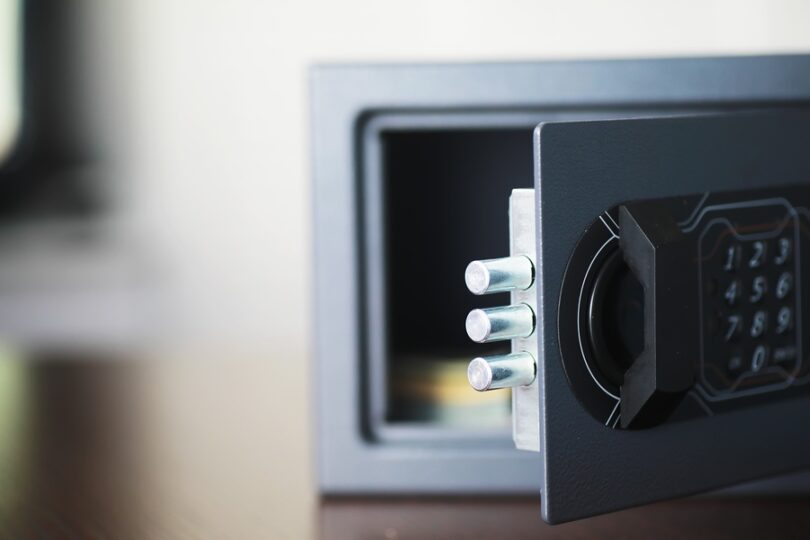 Close-up of open safe with keypad lock and metal bolts extended, showing secure locking mechanism and interior.