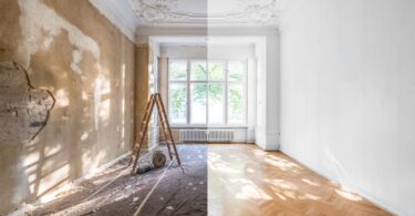 A room is split down the middle of the frame; the left half of the room is unfinished while the right half is fully finished.