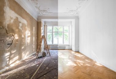 A room is split down the middle of the frame; the left half of the room is unfinished while the right half is fully finished.