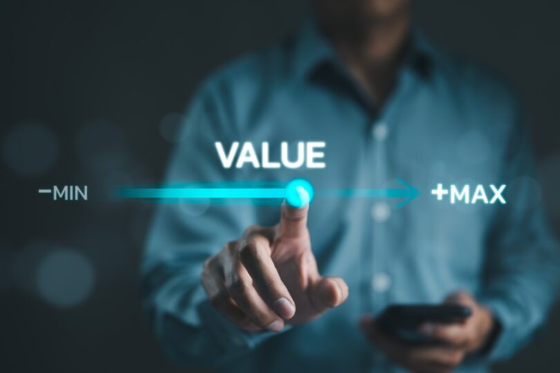 A man holding a calculator moves a point on a virtual progress bar labeled "value" from "min" to "max" with his finger.