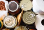 Assorted pantry supplies include canned goods, jars of beans and oats, dried beans, paper towels, and packaged food.