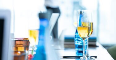 Champagne flutes and drinks arranged on a table at an elegant indoor event.