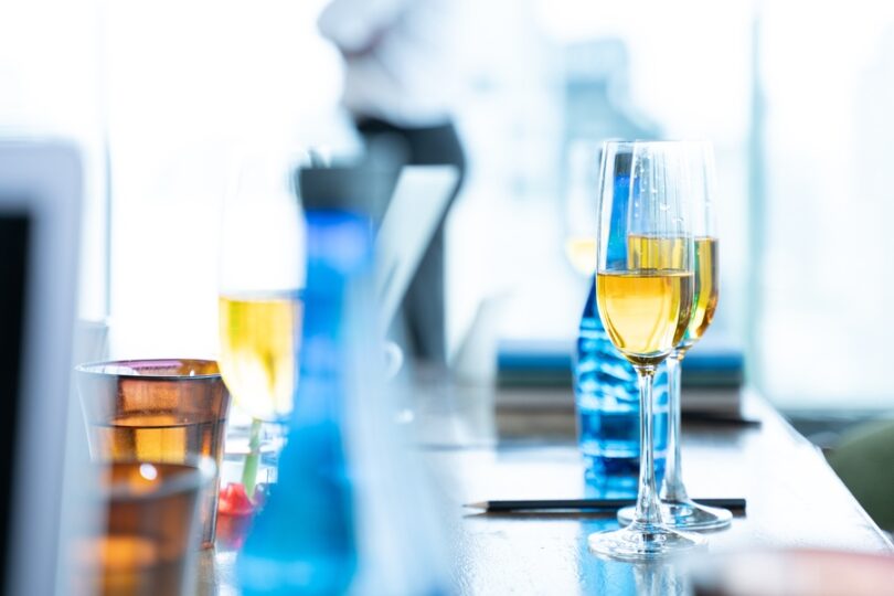 Champagne flutes and drinks arranged on a table at an elegant indoor event.